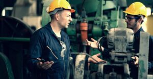 Zwei Personen im Maschinenbau besprechen eine Maschine in der Produktion